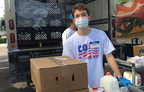 teenage volunteer loading a truck with milk