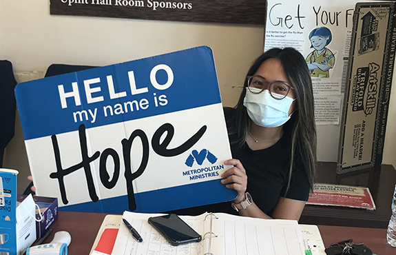 teenage girl filling out paperwork holding a Hope nametag
