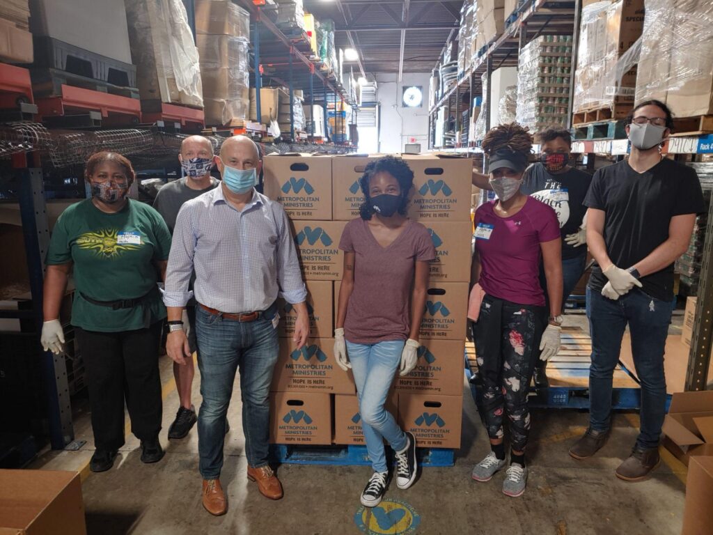 volunteers with boxes of supplies in warehouse